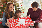Parents giving large Christmas gift to daughter
