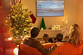 Family watching TV in Christmas living room