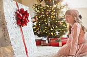 Girl smiling in anticipation at Christmas gift