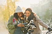 Young women friends using digital camera