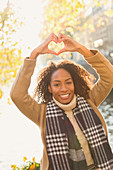 Young woman forming heart-shape with hands