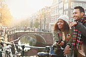 Young couple with bicycles on bridge