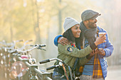 Young couple with bicycle drinking coffee