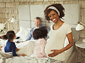 Pregnant woman in bedroom with young family