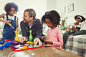 Father and daughters playing with toys