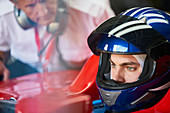 Focused formula one race car driver wearing helmet