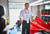Formula one manager next to race car