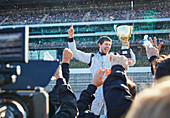 Formula one racing team spraying champagne