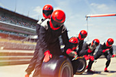 Pit crew preparing tires in formula one pit lane