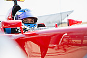 Focused formula one race car driver looking away