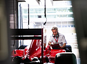 Manager examining formula one race car