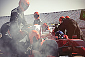 Pit crew replacing tires on formula one race car