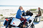 Senior woman on motorcycle on beach