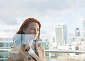 Confident businesswoman on balcony with city view