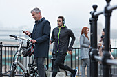 Businessman with bicycle and male runner on ramp
