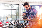 Motorcycle mechanic greasing engine part