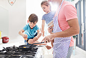 Father cooking breakfast with daughter and son