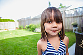 Portrait girl in bathing suit in summer backyard