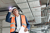 Foreman with flashlight at construction worker