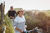 Mature couple walking bicycles