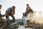 Mature couples barbecuing and drinking wine