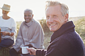 Portrait senior man drinking coffee with friends