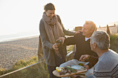 Mature friends drinking wine and enjoying barbecue