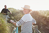 Portrait mature woman walking bicycle grass path