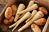 Parsnips and potatoes in wood crate