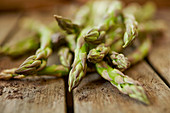 Fresh, green asparagus tips on wood