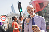 Portrait businessman with cell phone, London, UK