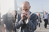 Businessman blowing nose