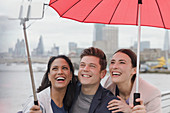 Tourists with umbrella taking selfie, London, UK