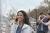 Smiling woman talking on cell phone, London, UK