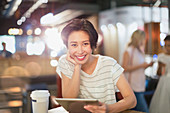 Portrait woman using tablet in cafe