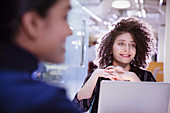 Smiling businesswoman at laptop listening