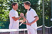 Smiling tennis players handshaking