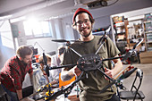 Portrait male designer holding drone in workshop