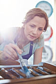 Focused painter painting furniture with blue paint