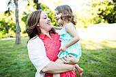 Smiling, affectionate mother holding daughter