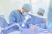 Surgeons operating on female patient