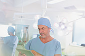 Mature male surgeon using digital tablet