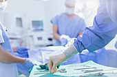 Surgeon reaching for surgical scissors