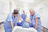 Caring surgeons pushing patient on stretcher