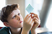 Curious, focused boy examining computer chip