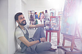Portrait artist with palette painting at easel