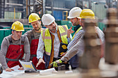 Male foreman, engineers and workers at laptop