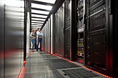 IT technicians talking at panel in server room