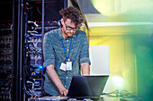 Male IT technician working at laptop