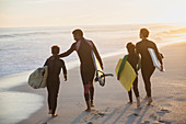 Family surfers walking with surfboards
